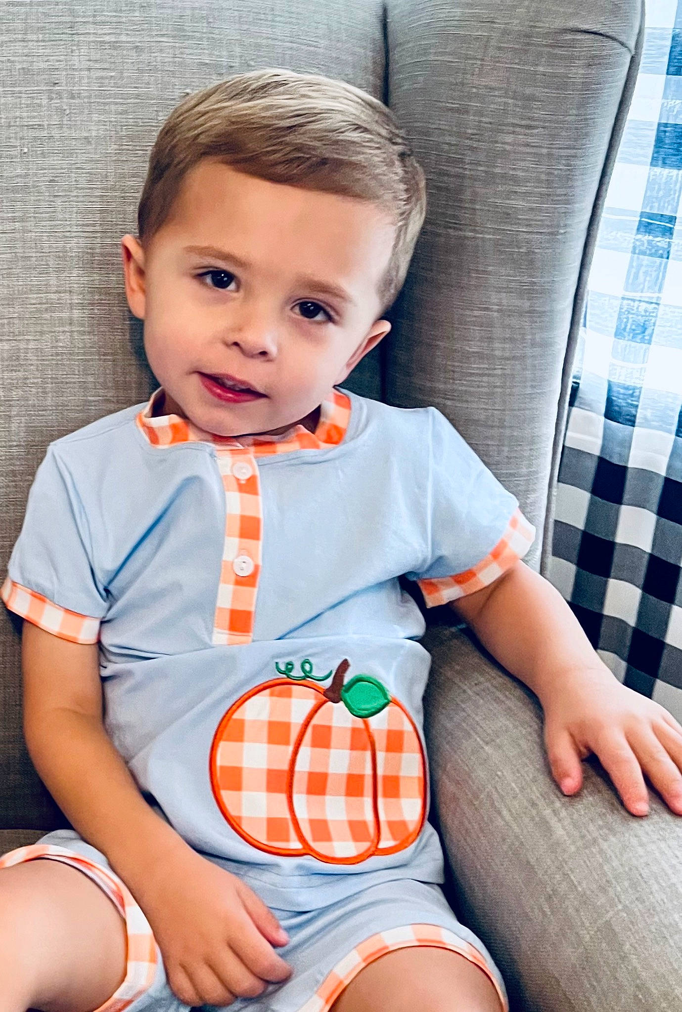 Arie is registered to the contest to win money with this photo: baby_toddler_clothing, child, clothing, collar, dress, happy, human_leg, knee, orange, pattern, person, plaid, skin, sleeve, tartan, textile, thigh, tie, toddler, trunk