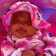 Sage joined the competition — help win amazing prizes! baby, infant, smiling, face, clothing, hat, pink, purple, floral_pattern, mesh_fabric, cute, child, portrait, happy, indoor, closeup, person, warm, cozy, playful