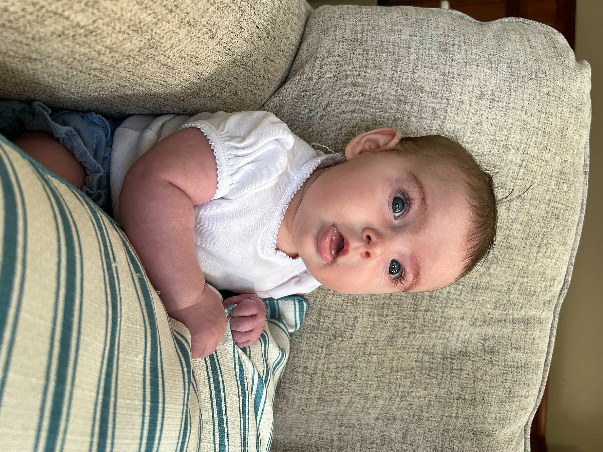 Aubrey Rae joined the competition — help win amazing prizes! baby, baby_toddler_clothing, cheek, child, chin, comfort, eye, face, flooring, head, iris, linens, lip, nose, pattern, person, sitting, skin, sleeve, surprise