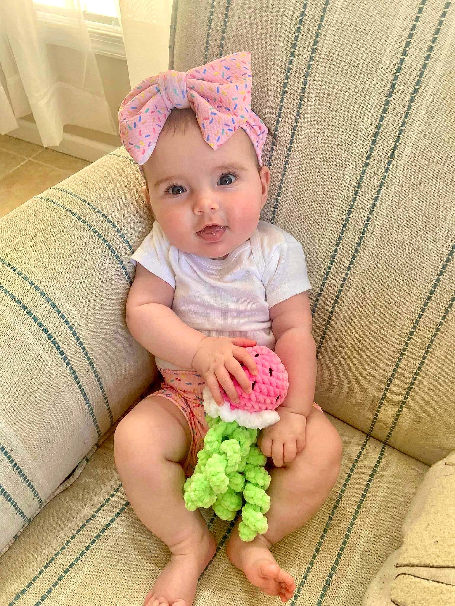 Aubrey Rae is registered to the contest to win money with this photo: baby, baby_toddler_clothing, cap, child, clothing, face, finger, grass, happy, headgear, headwear, human, leg, nail, person, pink, product, skin, sleeve, smile