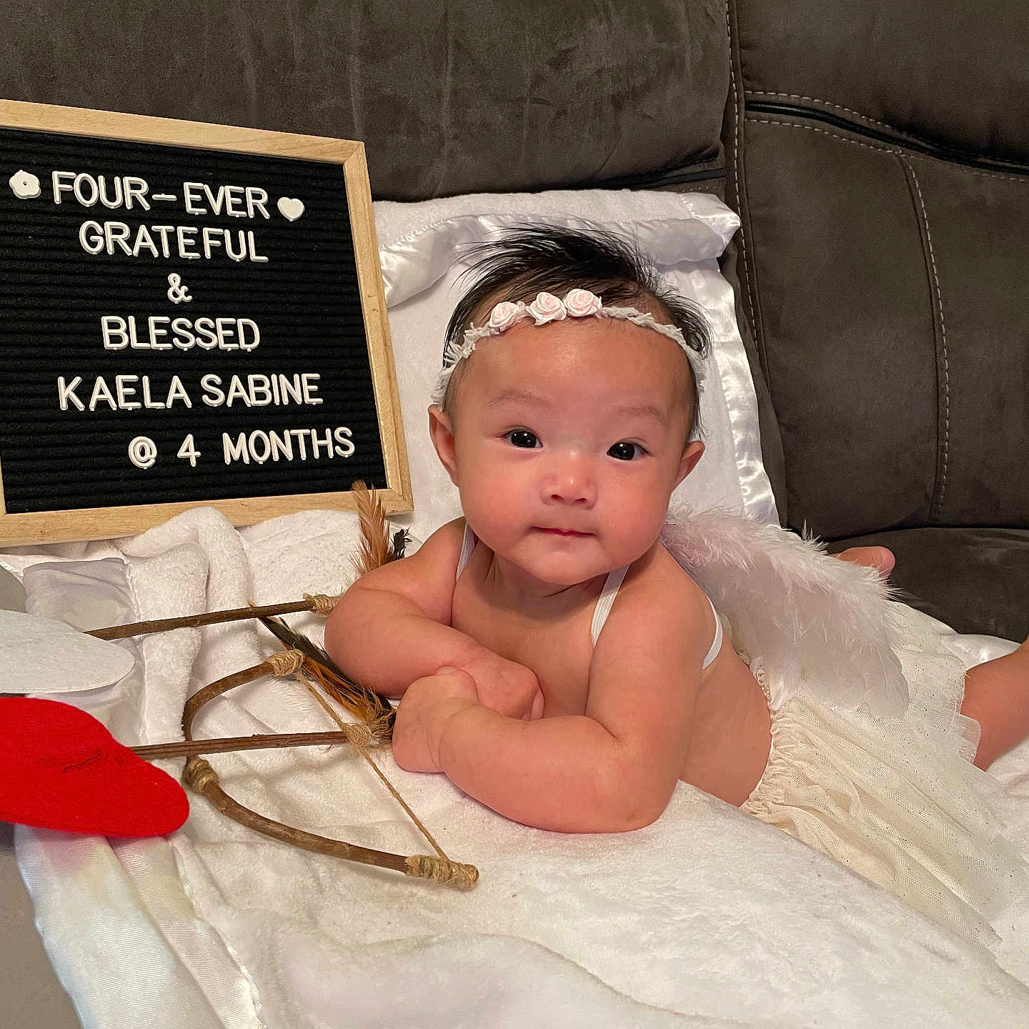 Kaela Sabine joined the competition — help win amazing prizes! angel_wings, baby, blanket, bow_and_arrow, couch, cute, decor, eyes, four_months, hands, headband, heart_prop, indoor, infant, letter_board, portrait, props, smiling, soft_lighting, tulle_skirt