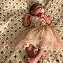 baby, sleeping, dress, pacifier, blanket, floral_pattern, infant, cute, peaceful, toddler, feet, crossed_legs, bedroom, soft_lighting, pink, fabric, quilt, child, newborn, resting