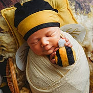 Harlow joined the competition — help win amazing prizes! newborn, baby, swaddled, blanket, bee_hat, plush_toy, sleeping, pillow, wooden_floor, cute, infant, soft_texture, yellow, black, white, child, portrait, cozy, peaceful, resting