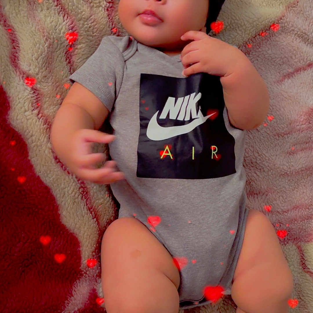 Kaileth is registered to the contest to win money with this photo: baby, infant, onesie, nike, socks, blanket, heart_effects, cute, chubby, indoor, portrait, child, young, fashion, laying_down, cozy, soft_texture, adorable, casual, relaxed