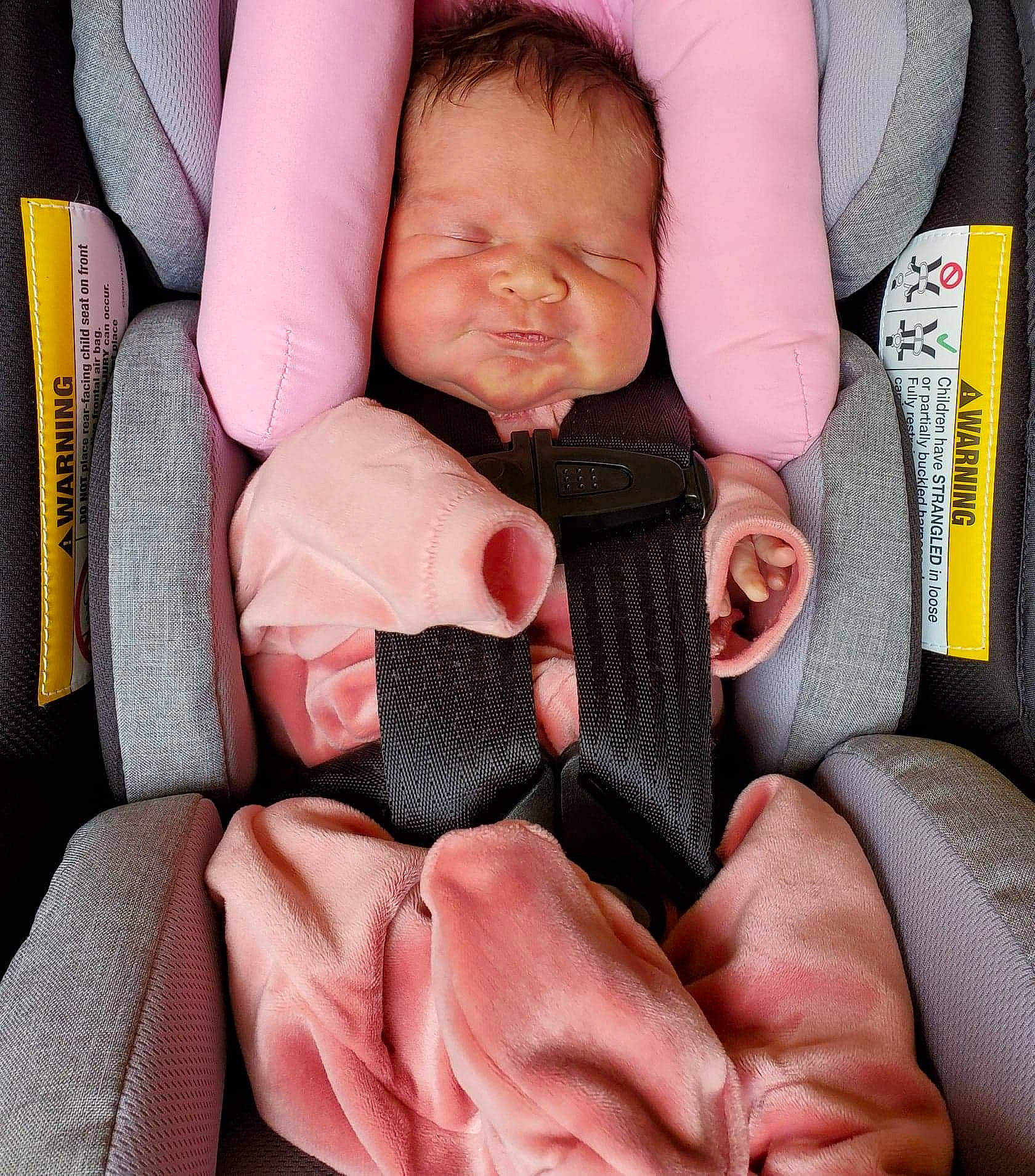 Arielle is registered to the contest to win money with this photo: auto_part, baby, baby_in_car_seat, baby_toddler_clothing, car_seat, cheek, child, comfort, face, finger, gesture, head, linens, nail, pattern, person, pink, seat_belt, textile, thumb