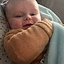 baby, infant, blanket, pacifier_clip, fuzzy_clothing, smiling, face, head, hand, pillow, stars_pattern, cozy, resting, indoors, soft_texture, cute, child, wearing, closeup, comfort