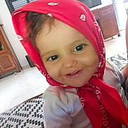 Salma a rejoint le concours — aidez-le/la à gagner de superbes lots ! baby, child, toddler, red_bandana, smile, face, indoor, furniture, television, carpet, wooden_cabinet, shirt, cheerful, young_child, headwear, person, home, closeup, cute, portrait