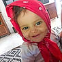 baby, child, toddler, red_bandana, smile, face, indoor, furniture, television, carpet, wooden_cabinet, shirt, cheerful, young_child, headwear, person, home, closeup, cute, portrait