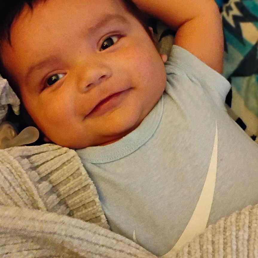 Makwa joined the competition — help win amazing prizes! baby, blanket, child, clothing, comfort, cozy, cute, face, happy, indoors, infant, mittens, patterned_blanket, portrait, relaxed, resting, smiling, soft_texture, warm, young_child