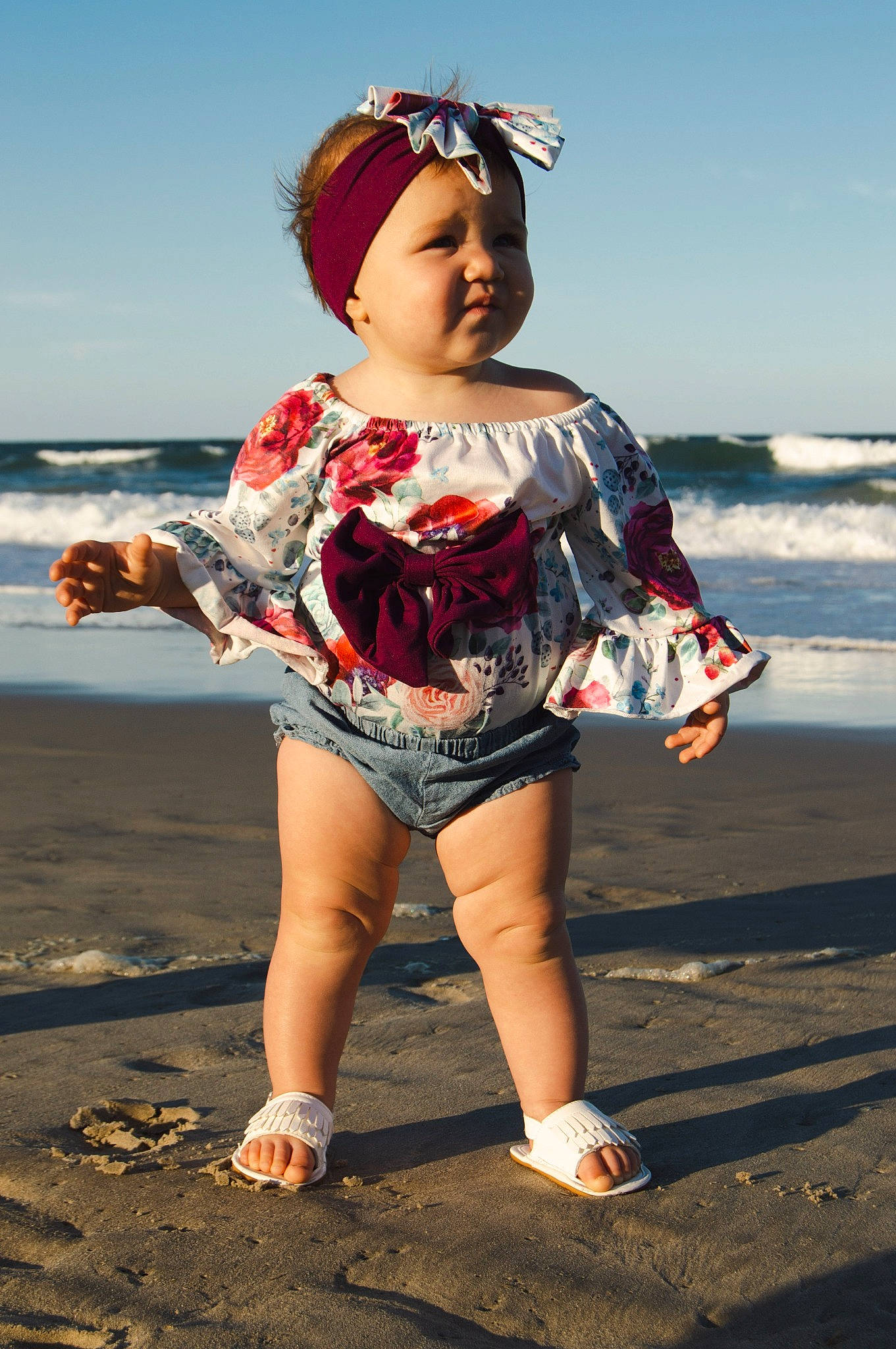 Millie joined the competition — help win amazing prizes! barefoot, beach, electric_blue, fashion_design, fun, happy, headgear, headwear, human_leg, natural_environment, person, personal_protective_equipment, sand, sky, sleeve, standing, street_fashion, sunlight, thigh, toddler