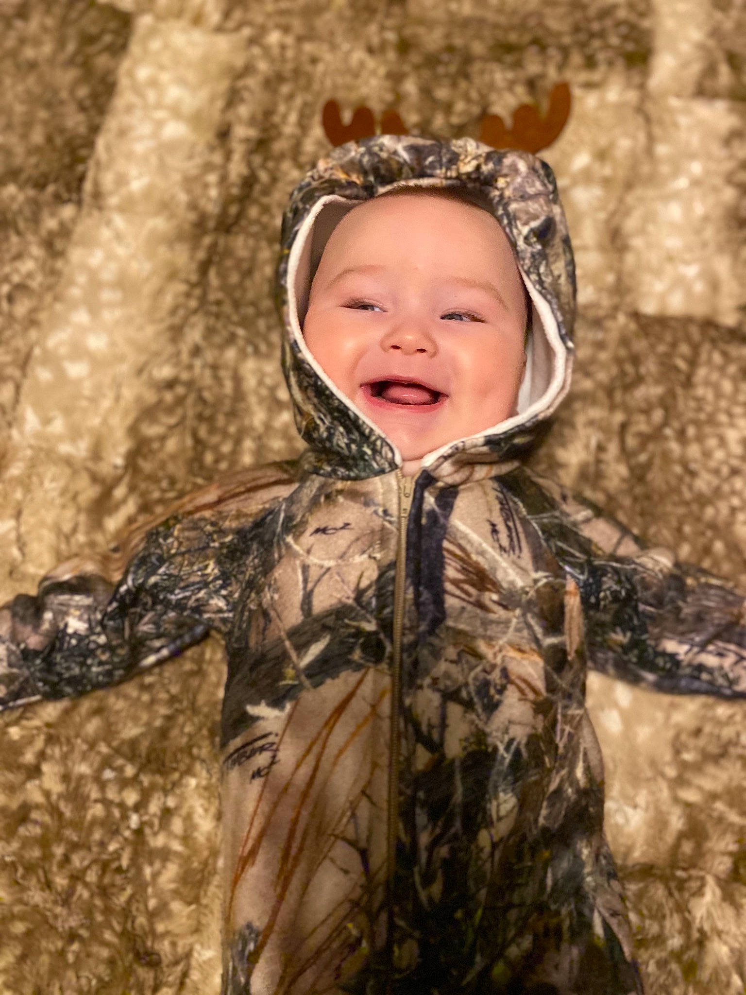 Hunter is registered to the contest to win money with this photo: camouflage, eye, face, facial_expression, flash_photography, fun, grass, happy, head, headgear, headwear, iris, mammal, military_camouflage, outerwear, people_in_nature, person, skin, smile, toddler