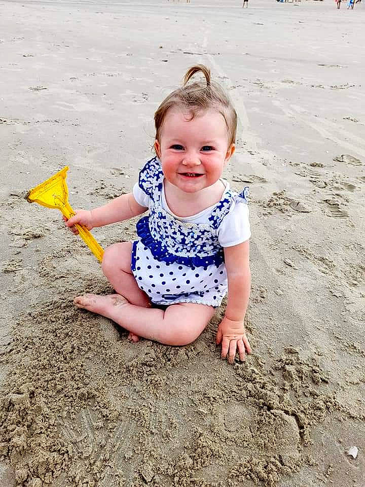 Chloe a rejoint le concours — aidez-le/la à gagner de superbes lots ! baby_toddler_clothing, barefoot, beach, child, foot, fun, happy, head, joy, leisure, people_in_nature, people_on_beach, person, recreation, sand, sitting, skin, smile, soil, standing