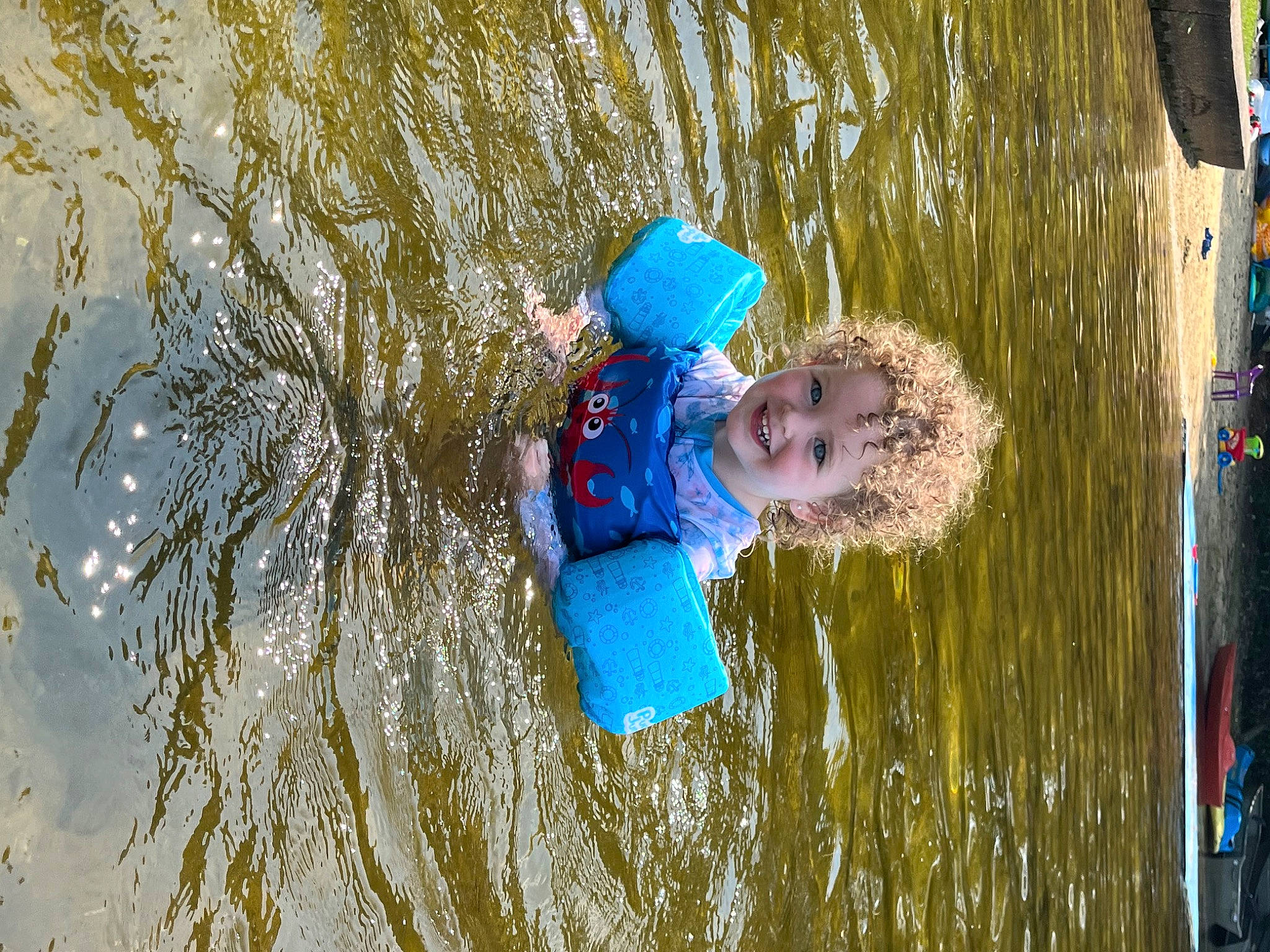 Eleanor is registered to the contest to win money with this photo: baby, baby_toddler_clothing, child, electric_blue, fun, grass, happy, hat, joy, leisure, people_in_nature, person, play, recreation, smile, sun_hat, toddler, vacation, water, winter