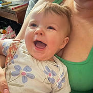 Luna joined the competition — help win amazing prizes! adult, baby, casual, child, closeup, cute, floral_clothing, furniture, green_tank_top, happy, holding, household_items, indoor, joyful, person, plush_toy, portrait, skin, smiling, table