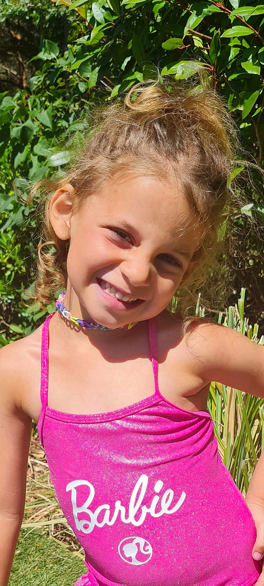 Emy a rejoint le concours — aidez-le/la à gagner de superbes lots ! child, girl, smiling, curly_hair, pink_swimsuit, barbie, outdoor, sunlight, greenery, nature, happy, portrait, summer, playful, cute, young, fashion, childhood, sunny, casual