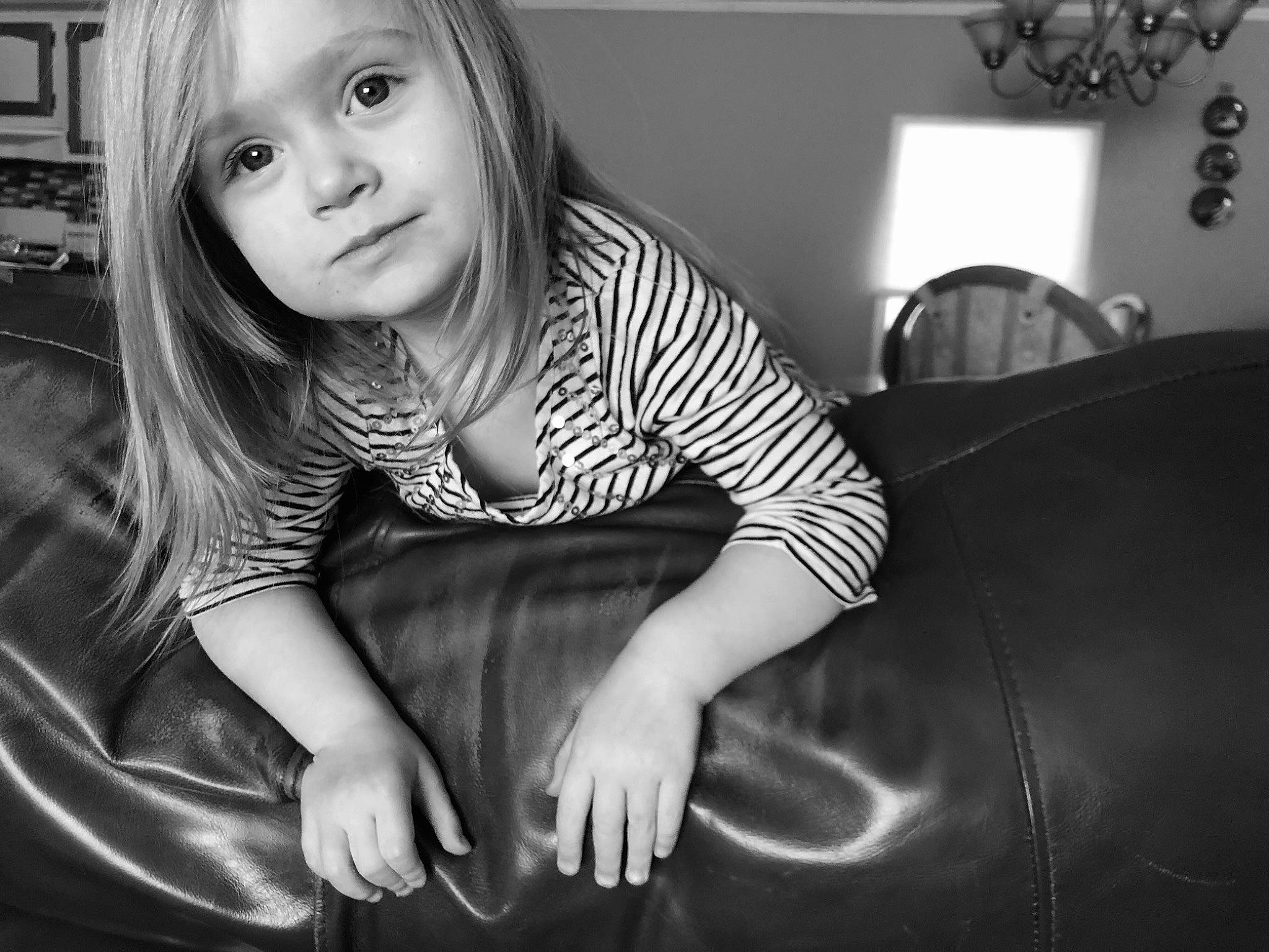 Izzy is registered to the contest to win money with this photo: arm, automotive_tire, black, black_and_white, black_hair, child, elbow, eye, finger, flash_photography, hairstyle, happy, head, iris, mouth, organ, person, smile, style, toddler