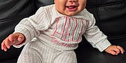 Aisha Hechvarria joined the competition — help win amazing prizes! baby, smiling, white_outfit, headband, bow, sitting, couch, leather, happy, cute, child, indoors, portrait, infant, feet, hands, cozy, knitwear, person, expression