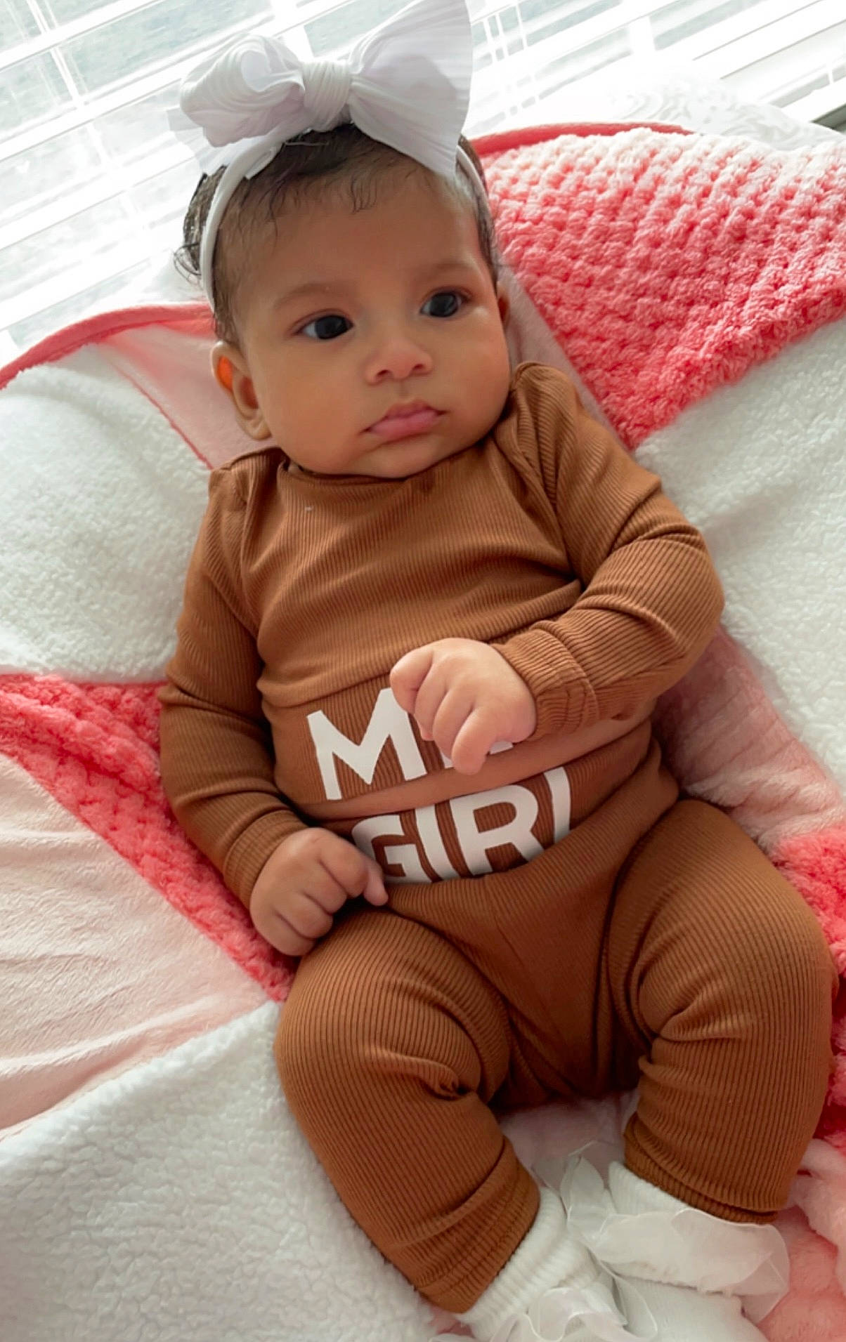 Gabriella is registered to the contest to win money with this photo: baby, baby_toddler_clothing, cheek, child, comfort, face, facial_expression, finger, flooring, grass, happy, linens, lip, person, pink, product, skin, sleeve, textile, toddler