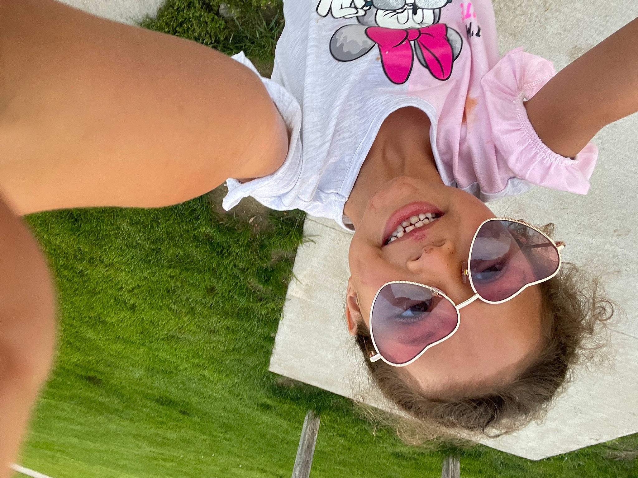 Mercedes is registered to the contest to win money with this photo: eyewear, finger, foot, fun, gesture, grass, happy, human_leg, jaw, joy, leisure, nail, pattern, people_in_nature, person, pink, skin, smile, thigh, thumb