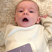 Maë participe au concours pour gagner de l'argent avec cette photo : baby, infant, face, eyes, mouth, blanket, pattern, clothing, sleeve, hand, milestone_card, stars, crescent_moon, lying_down, cute, young_child, indoors, soft_light, expression, skin