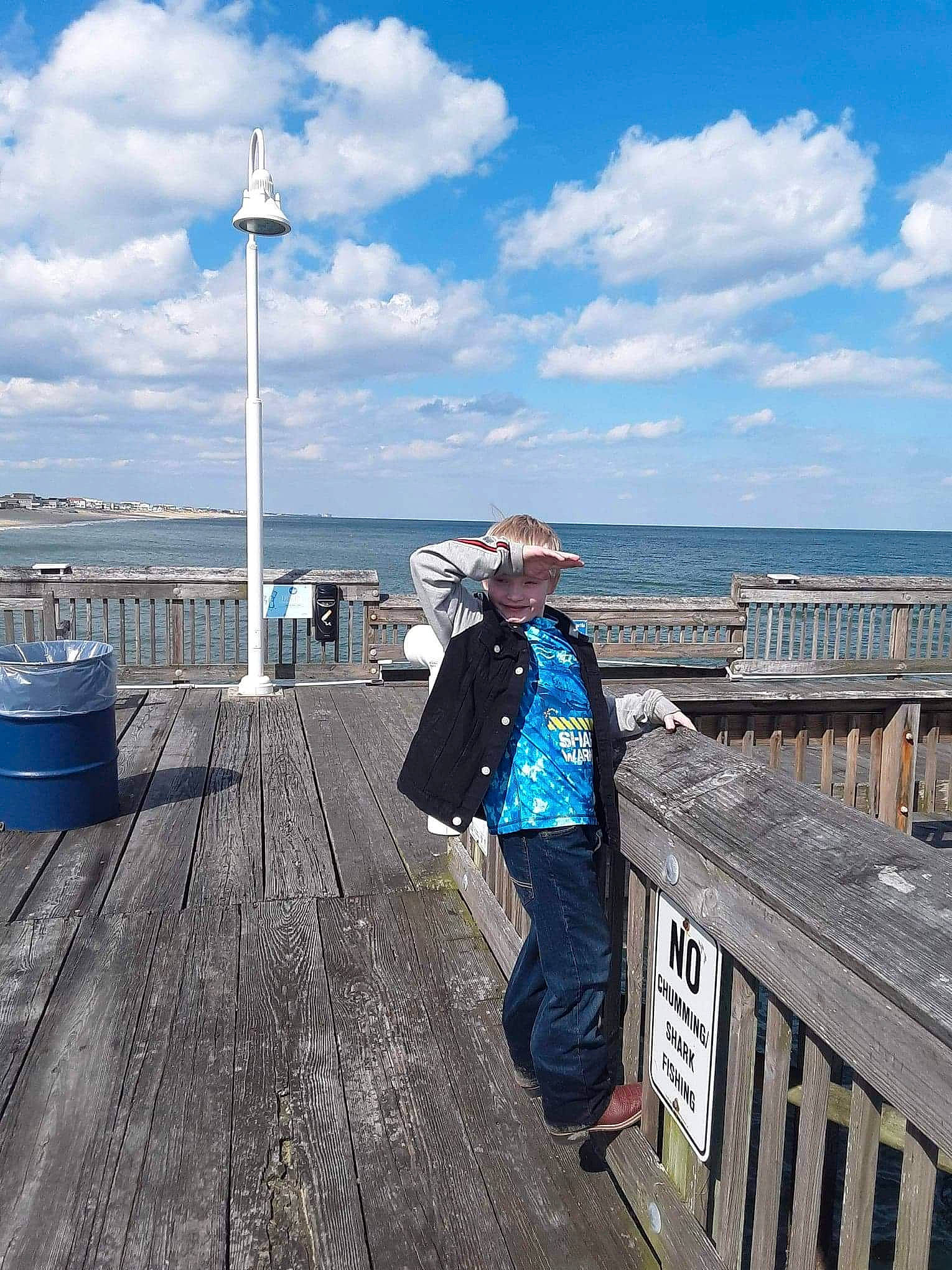 Jorden is registered to the contest to win money with this photo: architecture, beach, boardwalk, city, cloud, coast, guard_rail, headwear, joy, mountain, ocean, person, pier, sea, sky, sound, tourism, vacation, vehicle, walkway