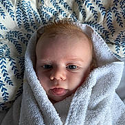 Louis a rejoint le concours — aidez-le/la à gagner de superbes lots ! baby, infant, towel, face, eyes, tongue, wrapped, blanket, blue, white, soft, cute, child, newborn, portrait, skin, expression, indoors, cozy, head