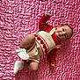 baby, infant, child, lying_down, romper, red_clothing, white_shoes, heart_pattern, pink_quilt, cute, smiling, portrait, indoor, soft_texture, happy, small_footwear, baby_fashion, closeup, adorable, infant_face