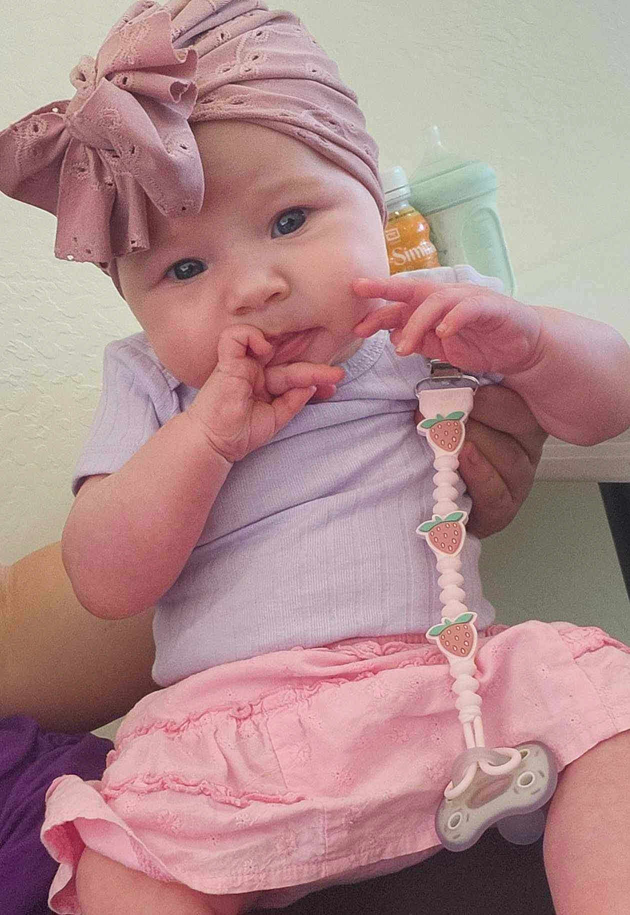 Autumn joined the competition — help win amazing prizes! baby, infant, child, headband, pink, purple, pacifier, pacifier_clip, skirt, sitting, hand, face, curious, indoor, person, clothing, cute, bottle, sippy_cup, holding