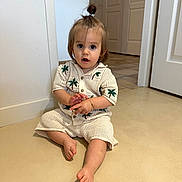 Noam a rejoint le concours — aidez-le/la à gagner de superbes lots ! toddler, child, indoor, floor, knit_clothing, palm_tree_pattern, sitting, curious_expression, ponytail, barefoot, bracelet, door, wall, tile_floor, light, portrait, person, young_child, cute, casual