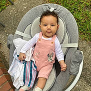 Azlynn is registered to the contest to win money with this photo: baby, infant, child, curly_hair, pink_overall, minnie_mouse, baby_rocker, gray_cushion, striped_cloth, white_shirt, outdoor, grass, concrete, brick, socks, smiling, seated, cute, person, toddler