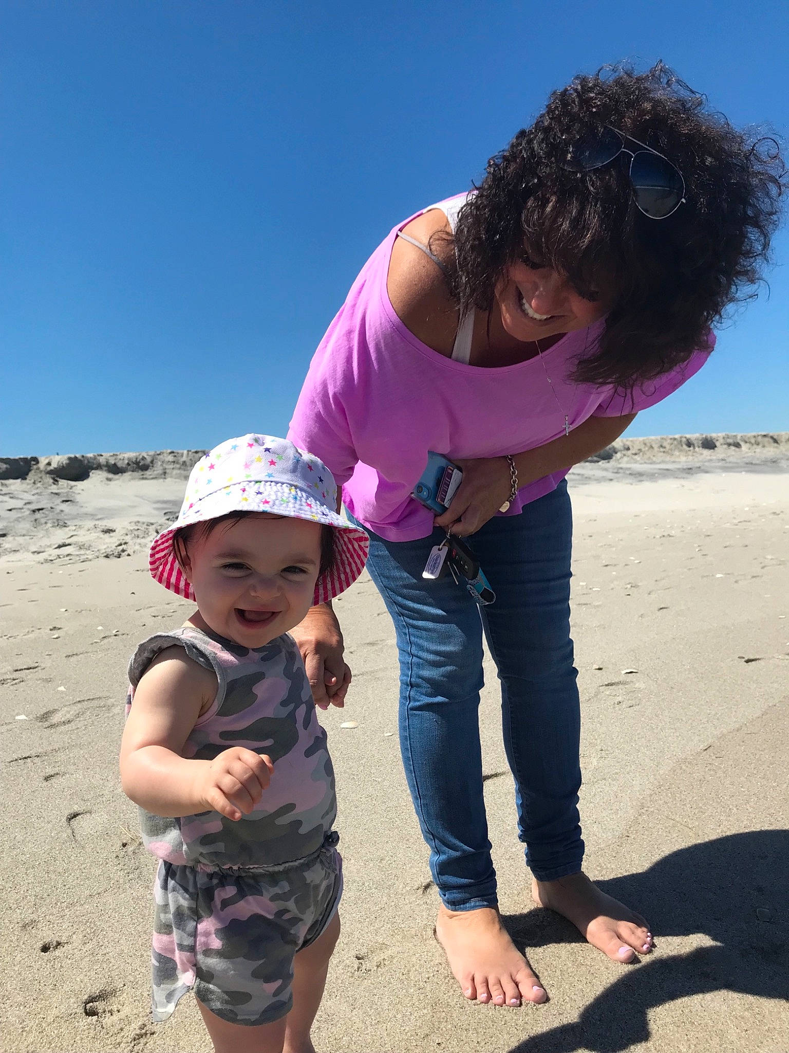 Giovanna is registered to the contest to win money with this photo: beach, child, coast, fawn, fun, headwear, joy, landscape, ocean, person, pink, plant, play, rock, sand, sea, sky, smile, summer, toddler