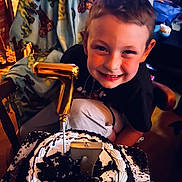 Lawson is registered to the contest to win money with this photo: birthday, cake, candle, celebration, chair, child, chocolate, clothing, dessert, face, food, happy, icing, indoor, number_seven, party, person, smiling, table, young_boy