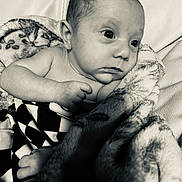 Knox is registered to the contest to win money with this photo: baby, black_and_white, blanket, closeup, comfort, couch, expression, face, foot, hand, indoor, infant, newborn, person, portrait, skin, soft, texture, wrapped, young