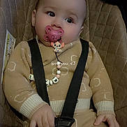 Maria participe au concours pour gagner de l'argent avec cette photo : baby, infant, pacifier, car_seat, seat_belt, buckle, onesie, sweater, bead_chain, toy, closeup, portrait, hand, eyes, looking_up, cozy, fabric, seat_padding, indoor, clip