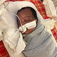 Karay is registered to the contest to win money with this photo: infant, baby, swaddled, sleeping, medical_tubes, hospital, blanket, towel, face, head, resting, healthcare, patient, care, newborn, indoors, closeup, wrapped, quiet, peaceful