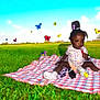 aircraft, airplane, blanket, child, clothing, face, female, girl, grass, head, hosiery, person, photography, plant, portrait, sitting, sock, summer, transportation, vehicle