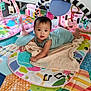Aaliyah is registered to the contest to win money with this photo: baby, infant, play_mat, toy, blanket, floor, colorful, indoor, child, romper, face, looking, cute, baby_toy, play_area, wooden_floor, furniture, plant, person, home