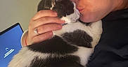 Nala joined the competition — help win amazing prizes! adult, black_and_white_cat, cat, cuddling, face, eyeglasses, hand, indoors, kissing, pet, pet_owner, portrait, sitting, soft_fur, tuxedo_cat, woman, affection, closeup, blue_screen, home