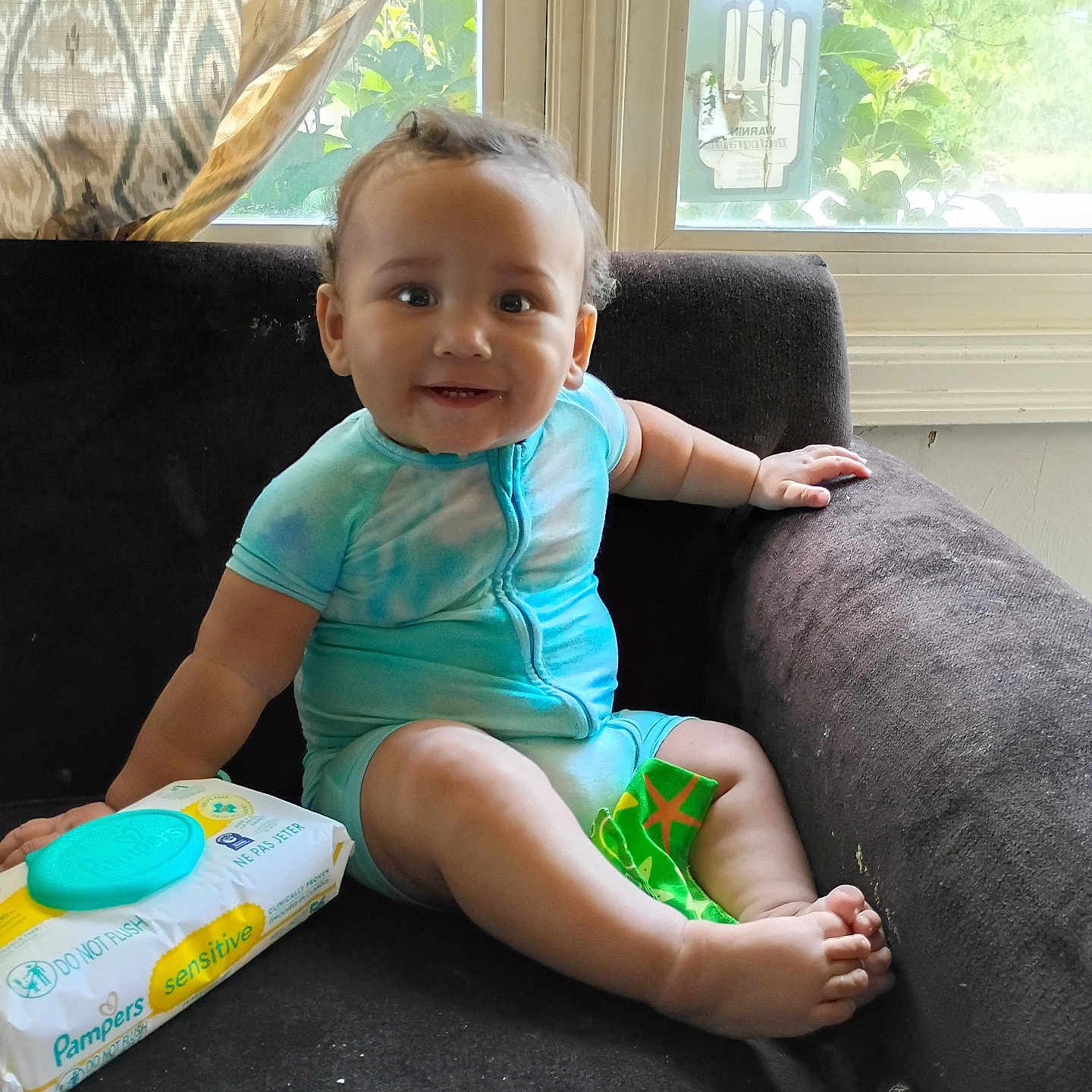 Karter joined the competition — help win amazing prizes! baby, child, toddler, smiling, sitting, portrait, indoor, armchair, window, sunlight, curtain, home, clothing, blue_outfit, barefoot, diaper_wipes, packaging, snack_wrapper, happy, infant