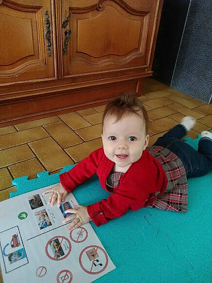 Julie participe au concours pour gagner de l'argent avec cette photo : baby, baby_toddler_clothing, carpet, child, floor, flooring, fun, hardwood, holiday, pattern, person, plaid, play, room, sitting, smile, tartan, toddler, varnish, wood