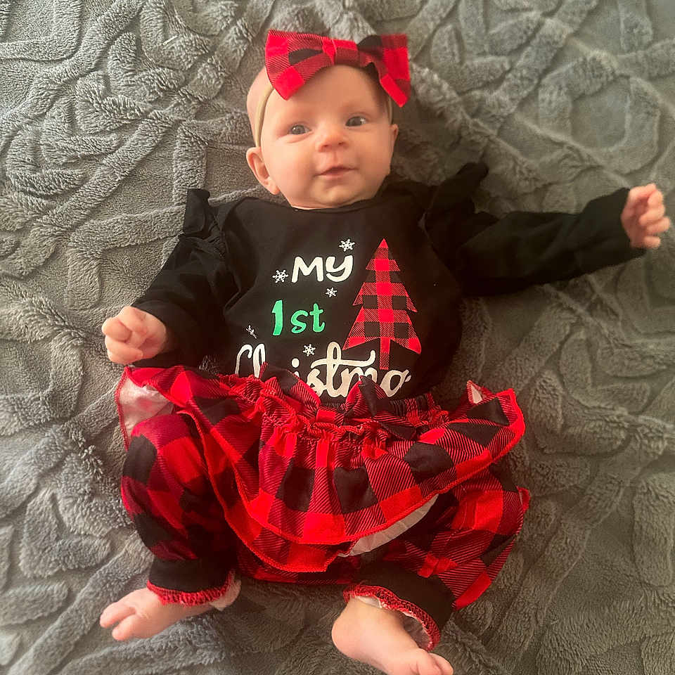 Maddison is registered to the contest to win money with this photo: accessories, baby, barefoot, bodypart, clothing, costume, dress, face, finger, formalwear, hand, hat, head, pants, person, photography, portrait, sitting, skirt, t_shirt