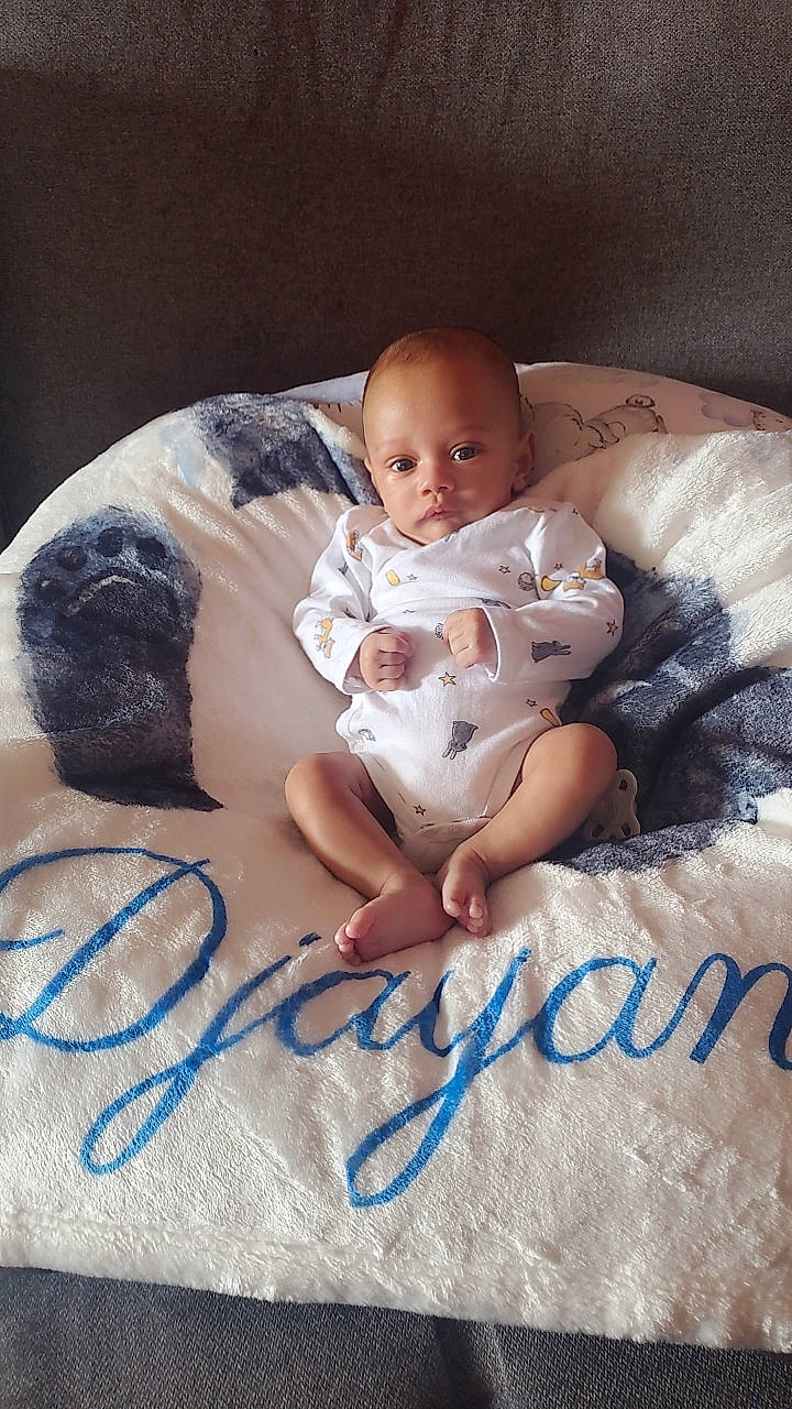 Djayan participe au concours pour gagner de l'argent avec cette photo : baby, baby_toddler_clothing, bedding, bedtime, child, comfort, flash_photography, font, foot, happy, linens, mammal, pattern, person, portrait_photography, room, sitting, stock_photography, t_shirt, textile