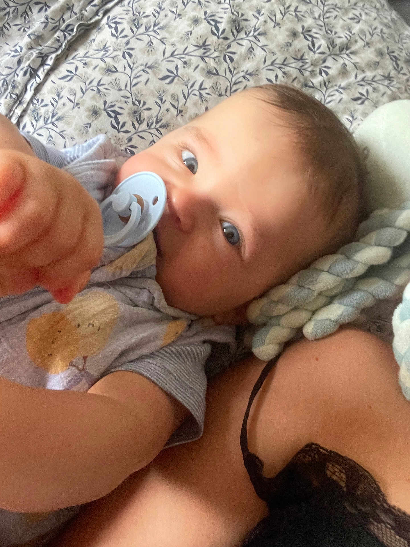 Aloïs a rejoint le concours — aidez-le/la à gagner de superbes lots ! baby, pacifier, infant, blanket, pattern, hand, blue_eyes, braided_toy, clothing, cute, closeup, bed, resting, soft_lighting, skin, person, child, toddler, indoor, cozy