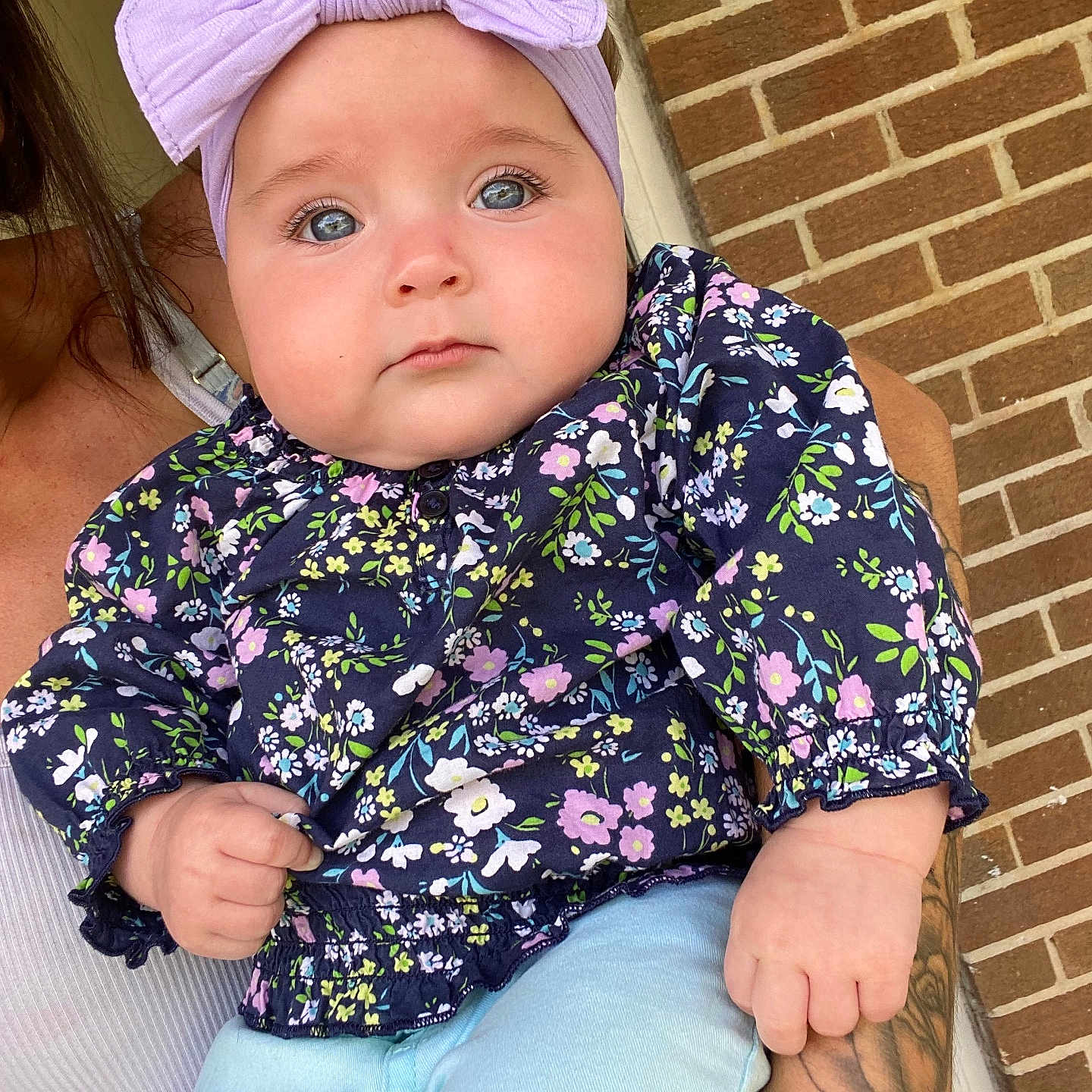 Lily is registered to the contest to win money with this photo: baby, baseballcap, blouse, brick, cap, clothing, coat, face, hat, head, jacket, jeans, pants, person, photography, portrait, shorts, sitting, skin, tattoo