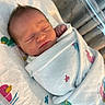 newborn, baby, sleeping, wrapped, blanket, hospital, bassinet, duck_pattern, infant, cute, peaceful, child, swaddled, face, head, skin, hair, indoors, resting, portrait