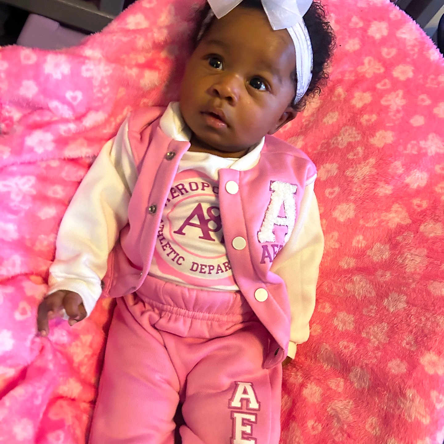 Aaliyah joined the competition — help win amazing prizes! baby, child, pink_clothing, headband, bow, blanket, pink_blanket, sitting, curious, infant, indoors, cute, portrait, face, person, cozy, soft_texture, clothing, comfortable, young_child