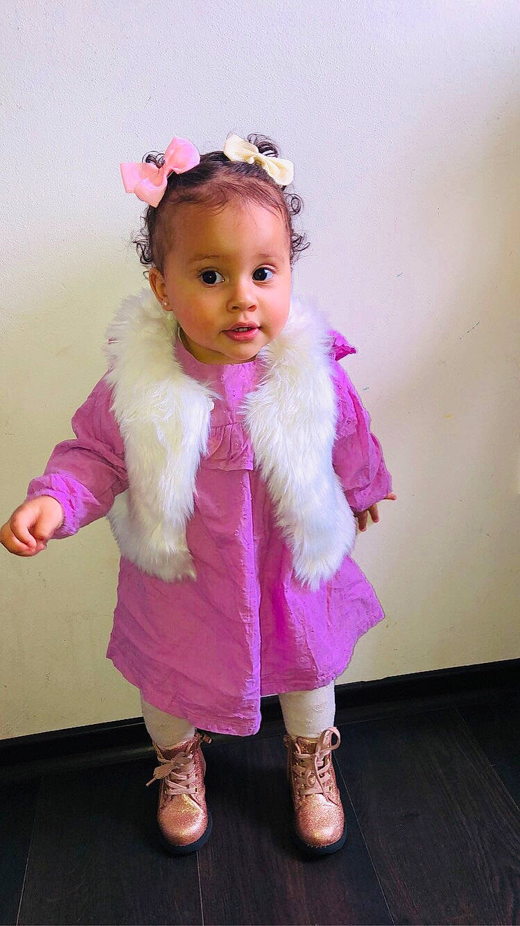 Naïah a rejoint le concours — aidez-le/la à gagner de superbes lots ! baby_toddler_clothing, cheek, dress, fashion_design, gesture, happy, head, headgear, iris, magenta, outerwear, person, pink, purple, shoe, skin, sleeve, sock, textile, toddler