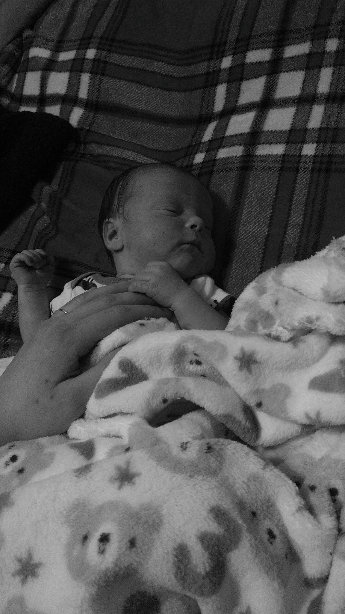 Roman is registered to the contest to win money with this photo: baby, baby_toddler_clothing, bedding, bedtime, cheek, chest, child, comfort, head, linens, mammal, monochrome, monochrome_photography, mouth, pattern, person, room, skin, tartan, textile