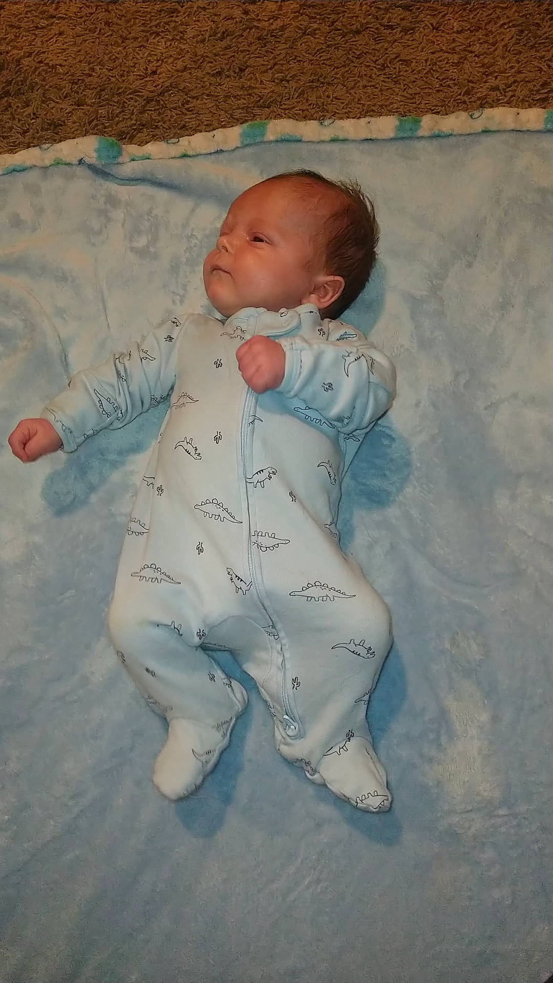 Roman is registered to the contest to win money with this photo: arm, baby, baby_toddler_clothing, cheek, child, comfort, eye, face, fun, hand, happy, head, human_body, linens, nose, pattern, person, sitting, skin, sleeve