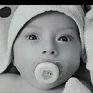 Livio participe au concours pour gagner de l'argent avec cette photo : baby, infant, pacifier, towel, hood, close_up, black_and_white, face, wide_eyes, skin, cute, newborn, child, soft_texture, wrapped, portrait, expression, innocent, young, person